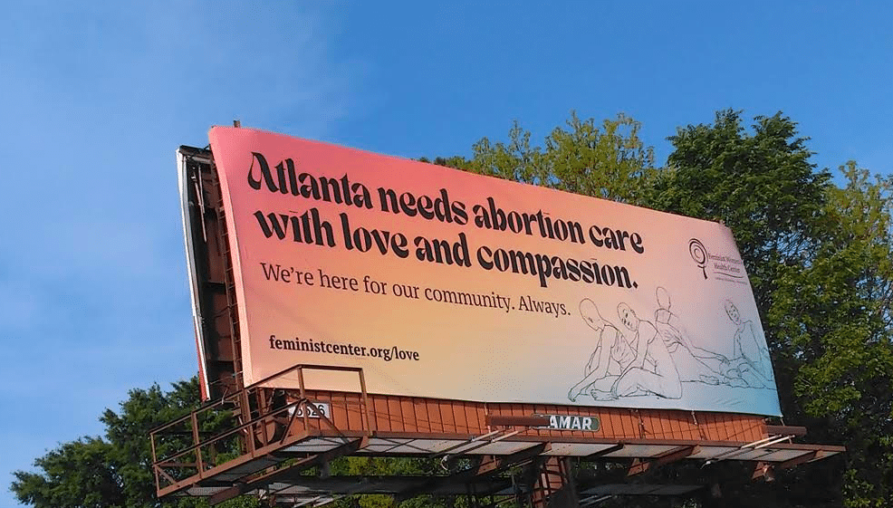 Photo of billboard with an ad that reads "Atlanta needs abortion care with love and compassion"