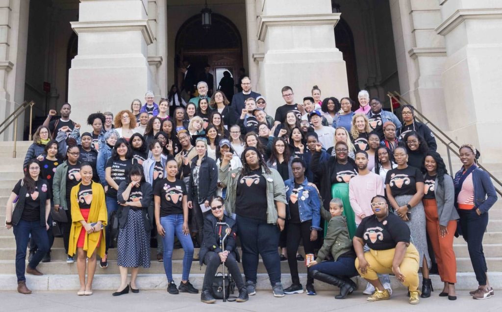 Demonstrators pose on the steps of the Georgia State Capitol.