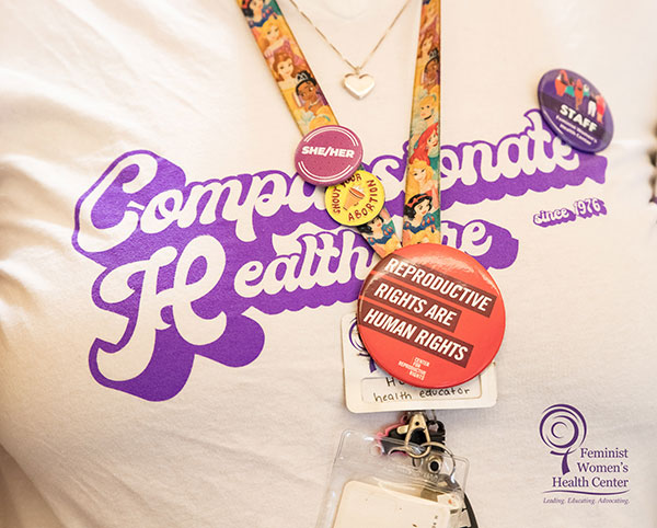 A close-up image of a staff member wearing a “Compassionate Healthcare since 1976” t-shirt.